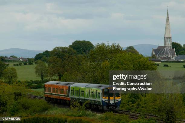 Two CIE DMUs in tandem head eastward past the white abbey at Kildare on Sunday 25th May 2003.