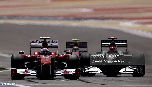 Fernando Alonso of Spain and Ferrari and Michael Schumacher of Germany and Mercedes GP drive side by side during the final practice session prior to...