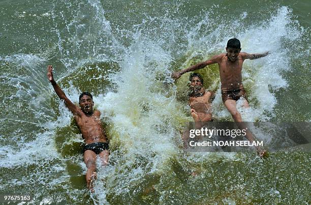 Indian youths jump into a river on the outskirts of Hyderabad on March 13 to beat the heat. Summer temperatures have begun to rise across India where...