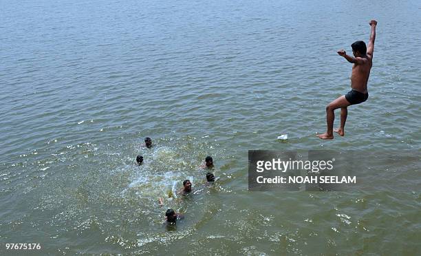 An Indian youth dives into a river on the outskirts of Hyderabad on March 13 to beat the heat. Summer temperatures have begun to rise across India...