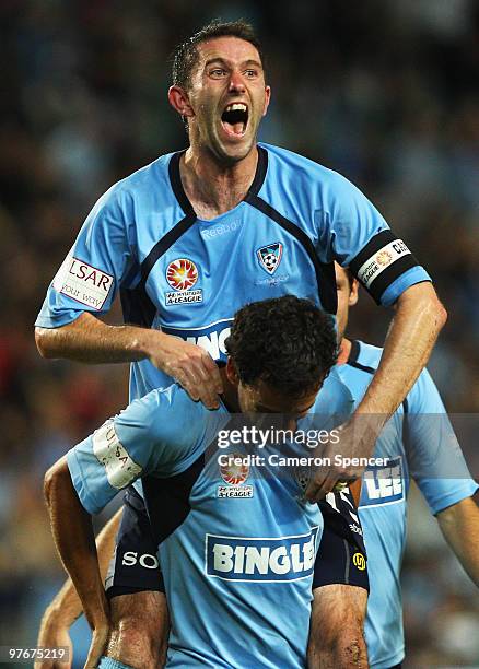 Terry McFlynn of Sydney celebrates with team mate Alex Brosque after Brosque kicked a goal during the A-League preliminary final match between Sydney...