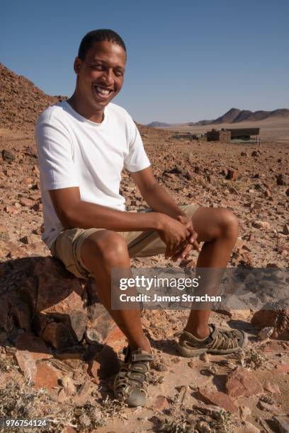 mountain and desert guide relaxing at desert homestead outpost - a good example of a multicultural namibian (a quarter each: herrero, nama, german and basters), namib-naukluft, namibia (model and property releases) - strachan stockfoto's en -beelden