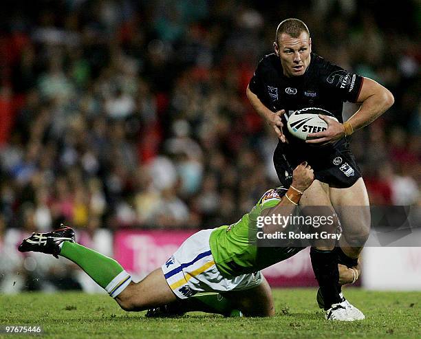 Luke Lewis of the Panthers is tackled by the Raiders during the round one NRL match between the Penrith Panthers and the Canberra Raiders at CUA...