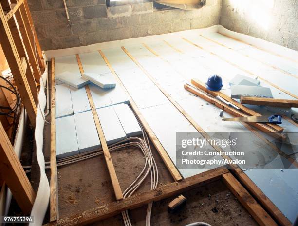 Floorboard insulation with polystyrene sheets and underfloor heating.