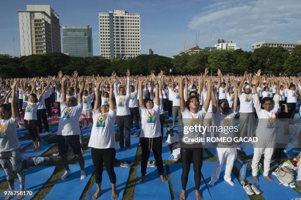 Hundreds of participants attend a mass yoga session at the grounds of Chulalongkorn University in Bangkok on June 17 ahead of the International Yoga...