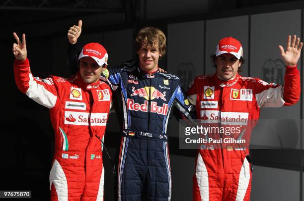Sebastian Vettel of Germany and Red Bull Racing celebrates taking pole position with second placed Felipe Massa of Brazil and Ferrari and third...