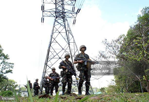 Philippine soldiers patrol under electricity lines in Nangka, Balo-i town, Lanao del Norte province in southern island of Mindanao on March 13, 2010....