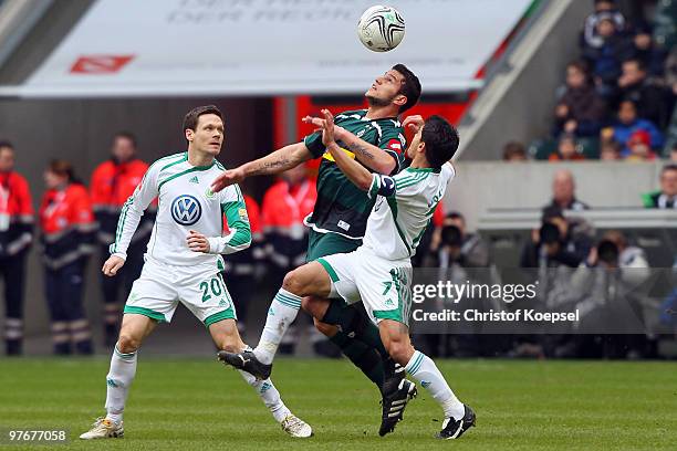 Sascha Riether of Wolfsburg and Josué of Wolfsburg challenge Rául Marcelo Bobadilla of Gladbach during the Bundesliga match between Borussia...