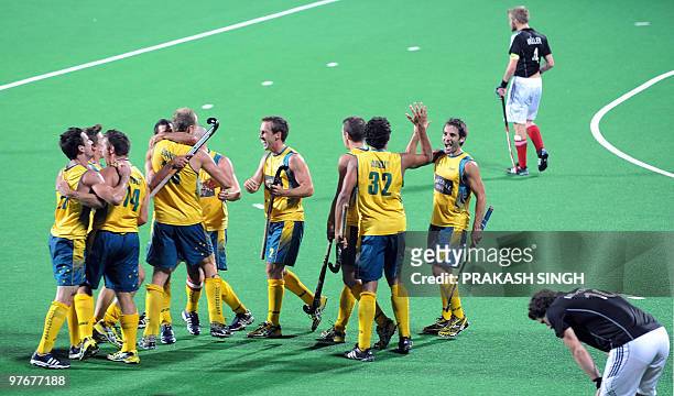 German hockey captain Maximillian Müller looks dejected as Australian hockey players celebrate after defeating Germany during their World Cup 2010...