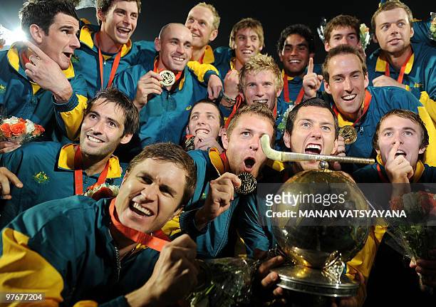 Australian hockey players pose with the trophy after winning the World Cup 2010 Final match against Germany at the Major Dhyan Chand Stadium in New...