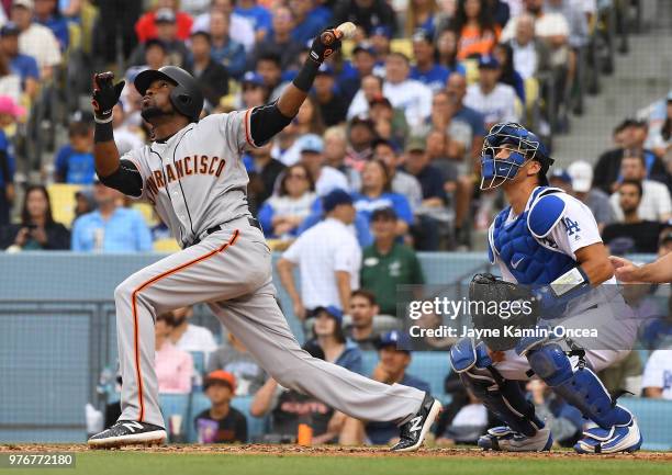 Austin Barnes of the Los Angeles Dodgers looks on as Alen Hanson of the San Francisco Giants hits a sacrifice fly to score Mac Williamson of the San...
