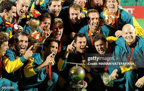 Australian hockey players pose with the trophy after winning the World Cup 2010 Final match against Germany at the Major Dhyan Chand Stadium in New...