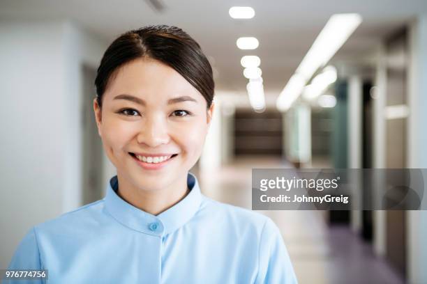 porträt von mitte adult krankenschwester lächelnd in richtung kamera - grübchen stock-fotos und bilder