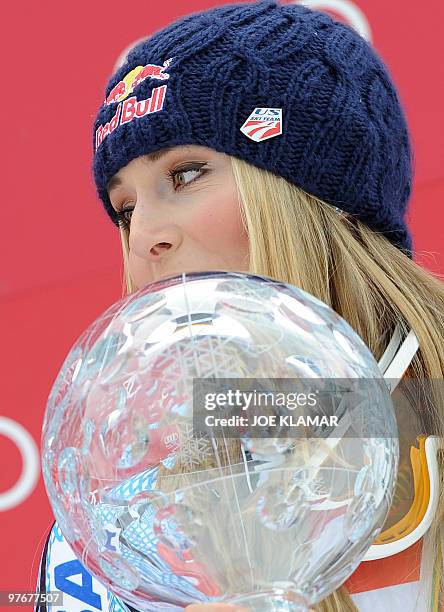 Overall world cup winner US Lindsey Vonn poses with the big globe in the finish area after the women's Alpine skiing World Cup Slalom finals in...