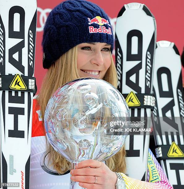 Overall world cup winner US Lindsey Vonn poses with the big globe in the finish area after the women's Alpine skiing World Cup Slalom finals in...