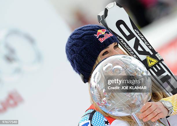 Overall world cup winner US Lindsey Vonn poses with the big globe in the finish area after the women's Alpine skiing World Cup Slalom finals in...