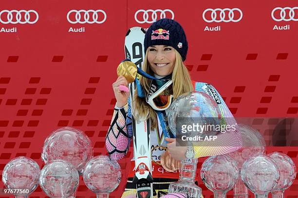 Overall world cup winner US Lindsey Vonn poses withall her globes in the finish area after the women's Alpine skiing World Cup Slalom finals in...