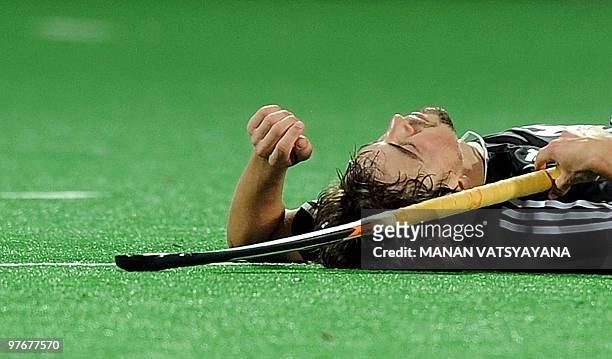 German hockey player Tobias Hauke lies dejected on the pitch after losing the World Cup 2010 Final match against Australia at the Major Dhyan Chand...