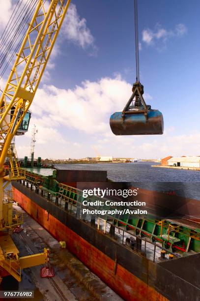 Unloading steel from the hold of a ship, Birkenhead dock, England, UK.