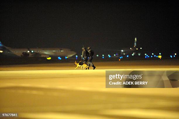 Indonesian anti-terror policemen walk on the tarmac during an anti-terror exercise in Tangerang on March 13, 2010. Indonesian police and the military...