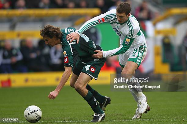 Edin Dzeko of Wolfsburg pulls Roel Brouwers of Gladbach during the Bundesliga match between Borussia Moenchengladbach and VfL Wolfsburg at Borussia...