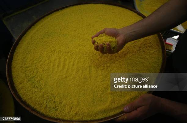Dpatop - A Palestinian man prepares a tray of Kanafeh at Al-Aqsa sweets shop in the West Bank city of Nablus, 11 April 2018. Kanafeh, a traditional...