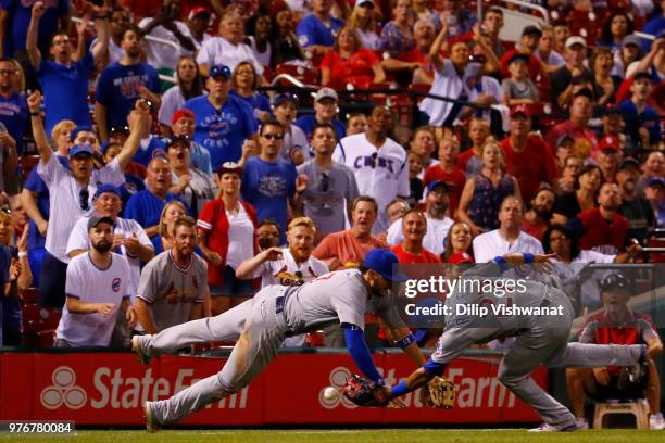 Kris Bryant and Addison Russell of the Chicago Cubs misplay a foul ball against the St. Louis Cardinals in the ninth inning at Busch Stadium on June...