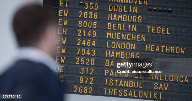 April 2018, Germany, Stuttgart: A passengers looks at the departure panel at Stuttgart airport. According to the airport's operator 'Flughafen...