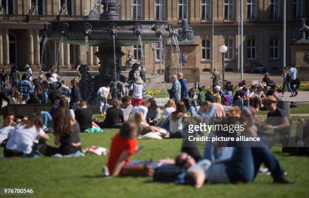 April 2018, Stuttgart, Germany: People laying on the lawn at the Schloss Palace. Photo: Marijan Murat/dpa