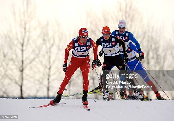 Johnny Spillane of the USA and Eric Frenzel of Germany compete in the team Gundersen 4x5km Cross Country event during day one of the FIS Nordic...