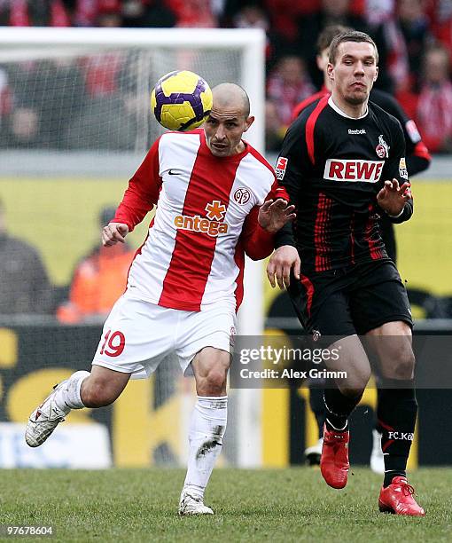 Elkin Soto of Mainz eludes Lukas Podolski of Koeln during the Bundesliga match between FSV Mainz 05 and 1. FC Koeln at the Bruchweg Stadium on March...