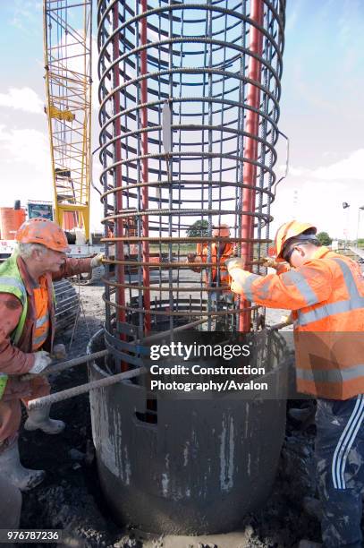 Construction crew at work fitting reinforcing into the piling.