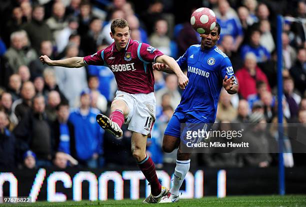 Jonathan Spector of West Ham clears the ball as Florent Malouda of Chelsea closes in during the Barclays Premier League match between Chelsea and...