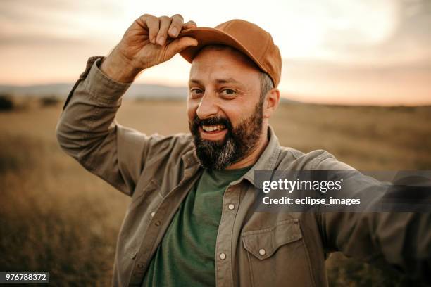 man making selfie in filed of wheat - occupation hats stock pictures, royalty-free photos & images