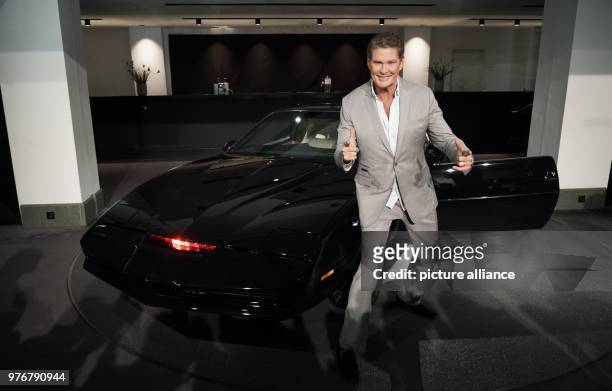 April 2018, Germany, Berlin: David Hasselhoff, American singer and actor, poses in front of his legendary sports car 'K.I.T.T' from the series...
