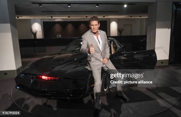 April 2018, Germany, Berlin: David Hasselhoff, American singer and actor, poses in front of his legendary sports car 'K.I.T.T' from the series...