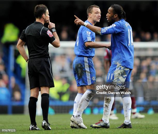 Didier Drogba of Chelsea argues with Referee Mark Clattenburg as his captain John Terry attempts to remove him from the situation during the Barclays...