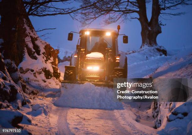 Farmer clearing snow from a lane near Ambleside of snow, Lake District, UK.