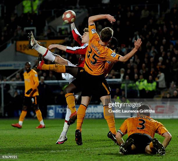 Nicklas Bendtner of Arsenal battles with Bernard Mendy of Hull City to score the first goal during the Barclays Premier League match between Hull...