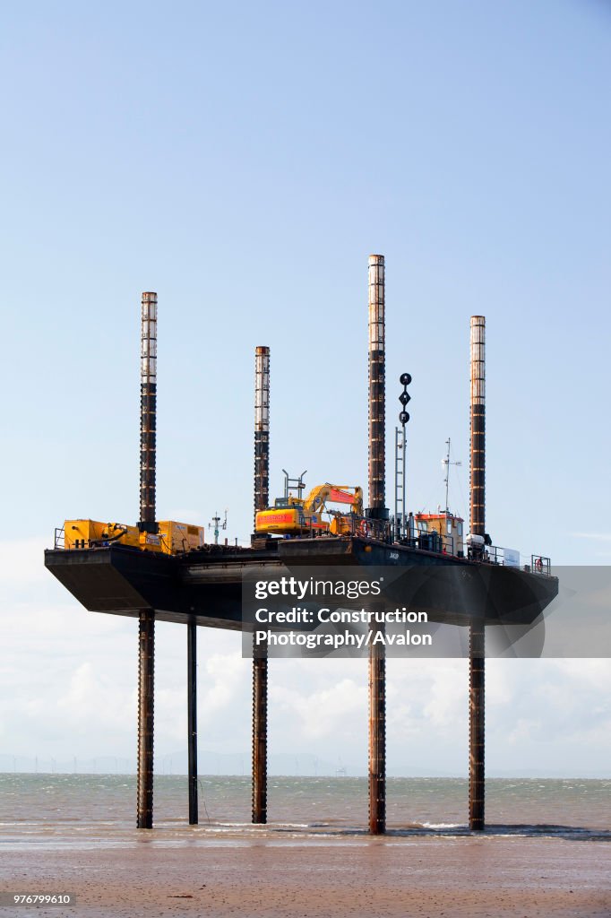 A jack up barge working on the foreshore of the Solway Firth near Workington, installing the power cable that will carry the electricity from the new Robin Rigg offshore wind farm in the Solway Firth. Robin Rigg is one of the largest wind farms in the UK