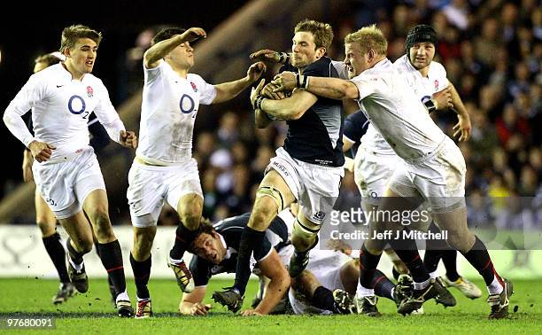 John Barclay of Scotland is tackled by Toby Flood , Danny Care and Dan Cole of England during the RBS Six Nations match between Scotland and England...