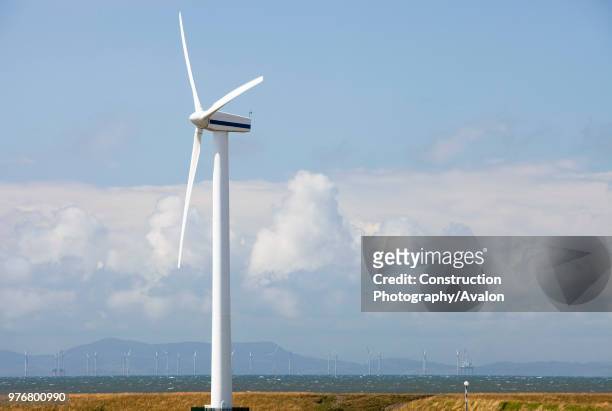 An onshore wind turbine on the outskirts of Workington, Cumbria, UK In the background is the new Robin Rigg offshore wind farm in the Solway Firth...