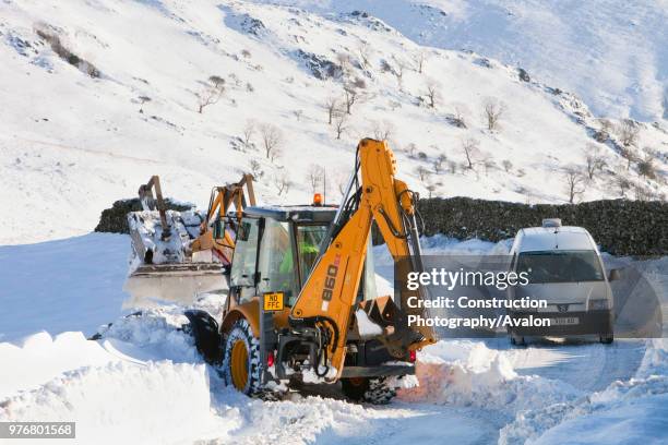 Charlie Middleton, an employee of cumbria vounty council clears snow from the blocked Kirkstone Pass, the highest mountain pass in the Lake District...