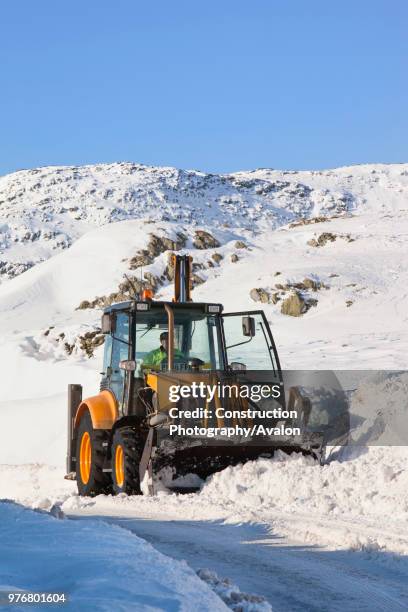 Charlie Middleton, an employee of cumbria vounty council clears snow from the blocked Kirkstone Pass, the highest mountain pass in the Lake District...