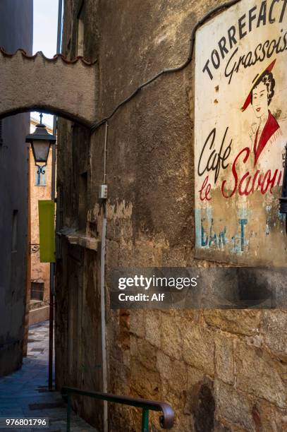 old wall advert of woman drinking coffee for le savoy café bar or coffee house on place aux aires, grasse, provence-alpes-côte d'azur, france - region provence alpes côte dazur stock-fotos und bilder