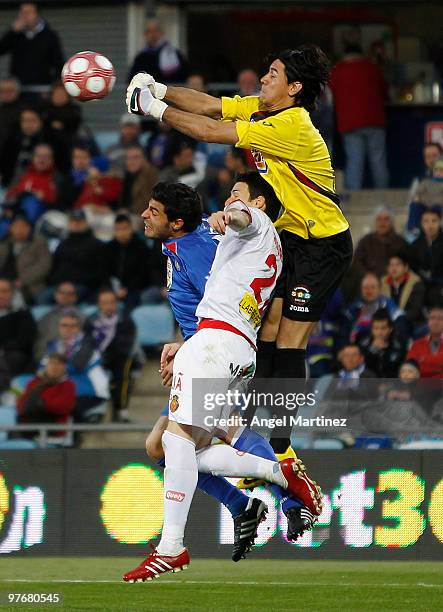 Oscar Ustari of Getafe fists the ball against Aritz Aduriz of Mallorca and Miguel Torres of Getafe during the La Liga match between Getafe and...