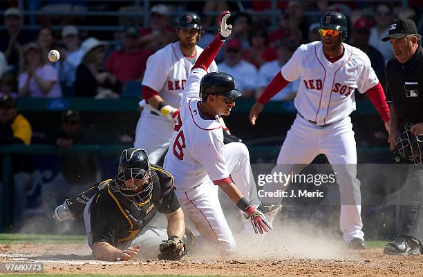 Catcher Erik Kratz of the Pittsburgh Pirates cannot handle the throw as infielder Jose Iglesias of the Boston Red Sox scores during a Grapefruit...