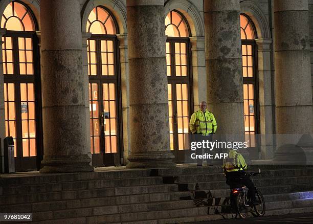 Irish police await the arrival of one of four people outside the Waterford court house in Waterford, Ireland on March 13, 2010. Police have arrested...