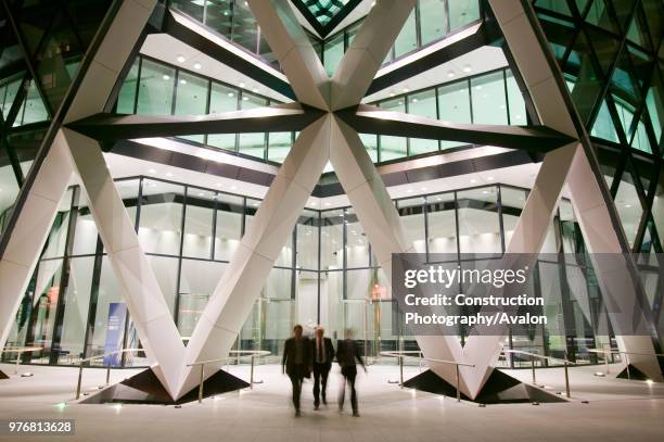 Office workers leaving the Swiss Re Tower at night in London UK.