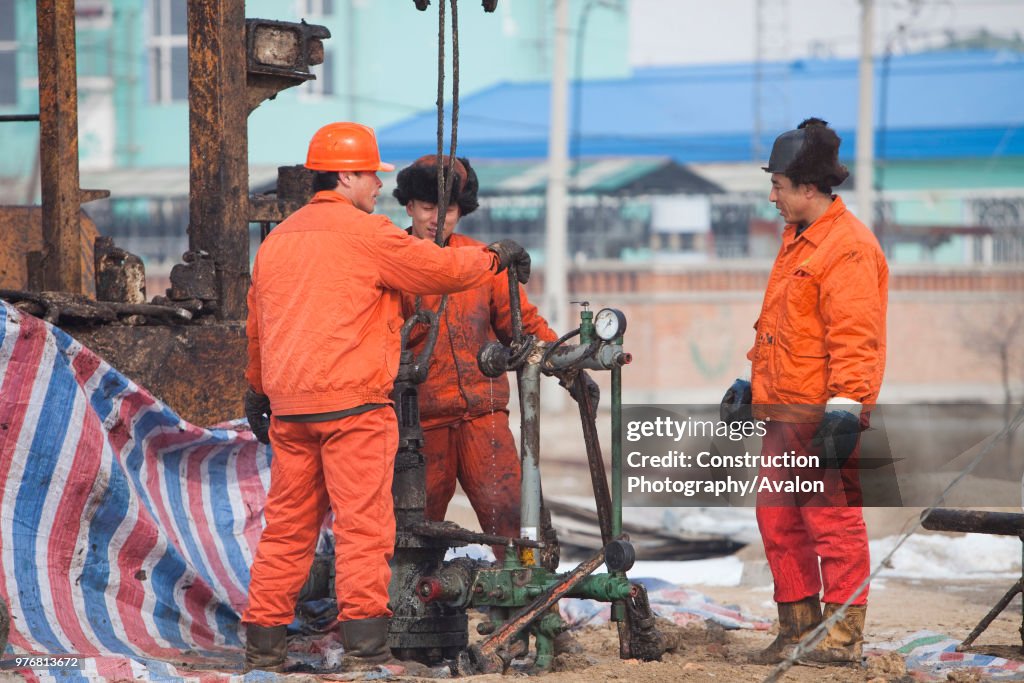 Oil workers drilling a new oil well in the Daqing oil field in Northern China